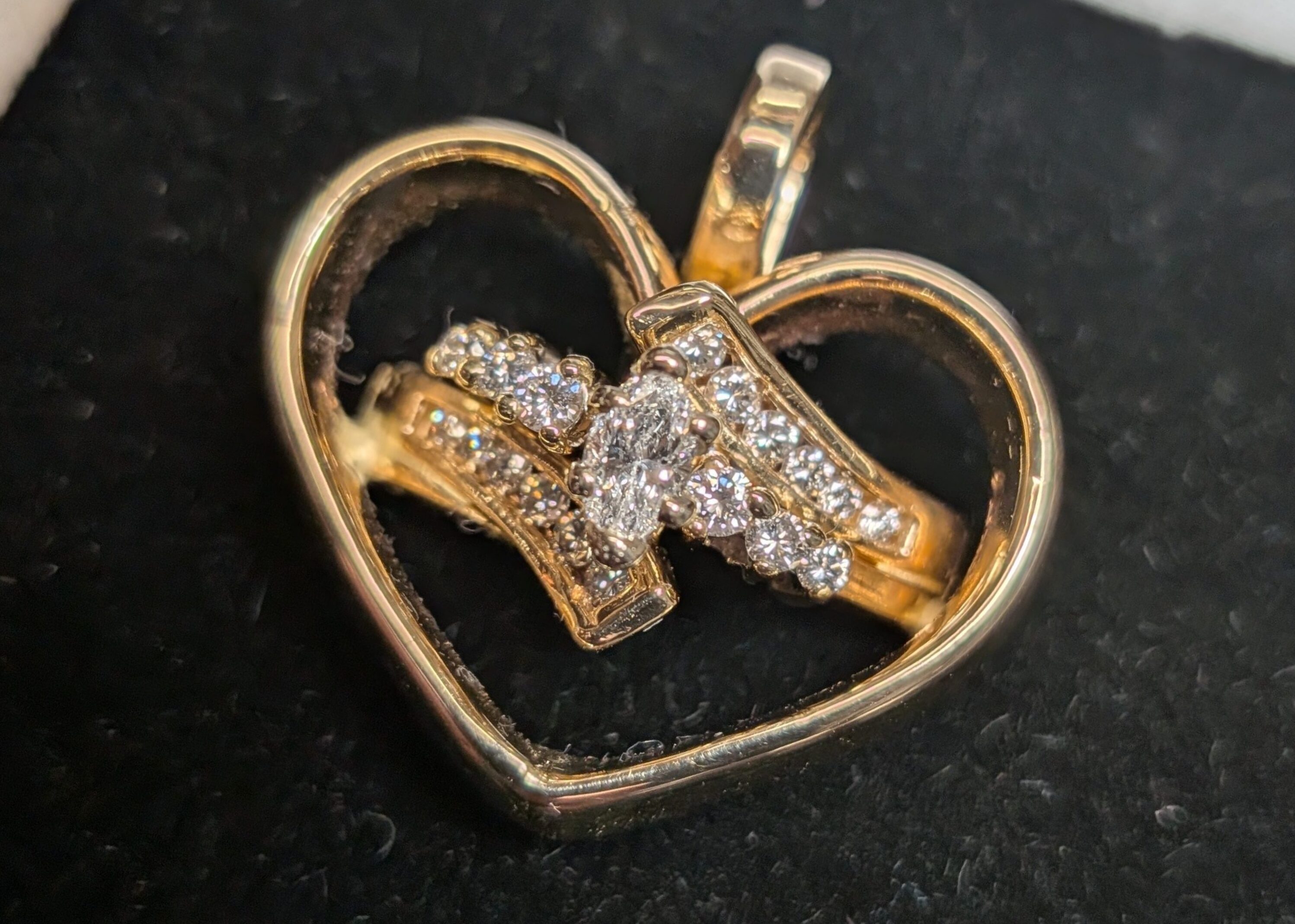 Heart shaped jewelery item in black velvet lined ring box